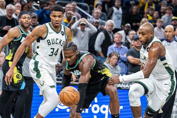 Indiana Pacers guard Bennedict Mathurin (00) dribbles the ball while Milwaukee Bucks forward Giannis Antetokounmpo (34) and forward Khris Middleton (22)